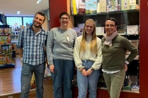 Ein Mann und drei Frauen stehen vor einem Bücherregal in der Buchhandlung Bücher König in Neunkirchen. 