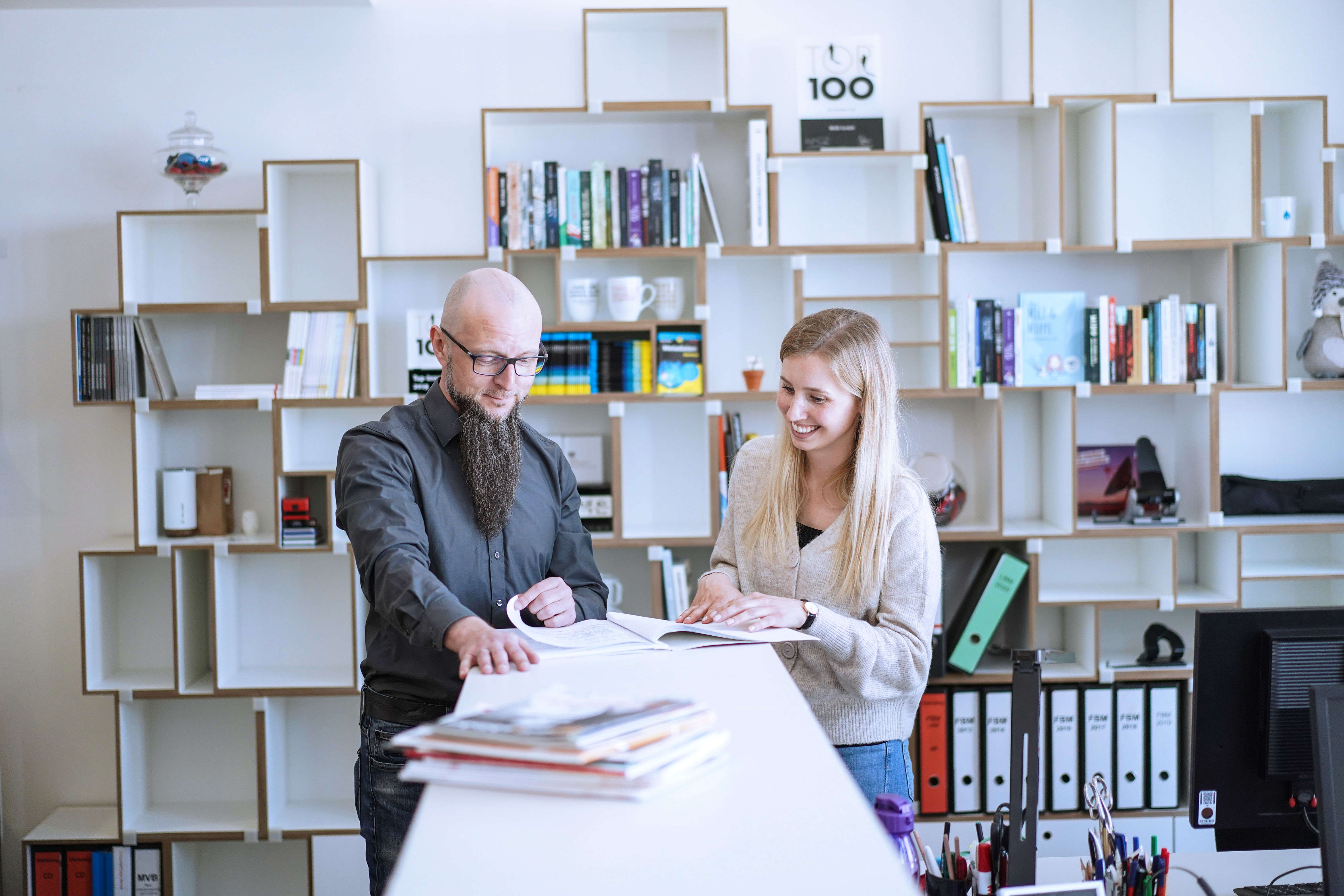 Zwei MVB Mitarbeiter im Gespräch vor einem Bücherregal