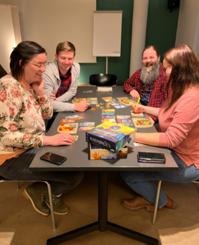 Mitarbeiter sitzen am Tisch und spielen Gesellschaftsspiele.
