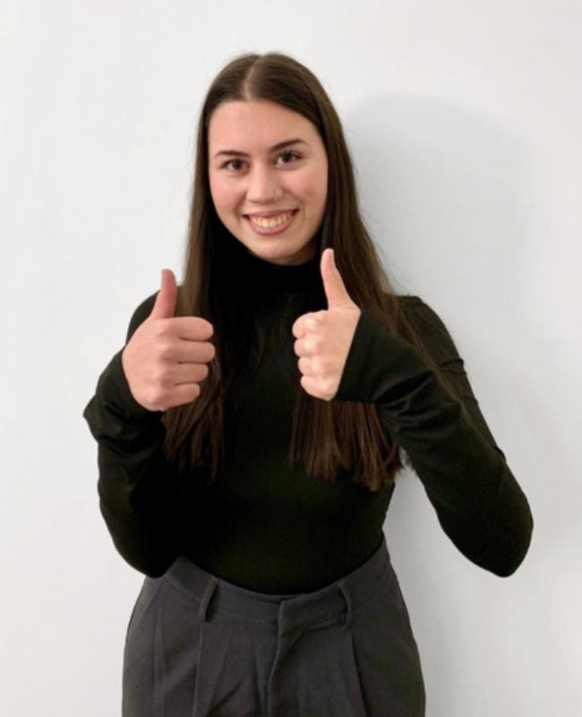 Yelda Altan hält beiden Daumen nach oben und lächelt in die Kamera.