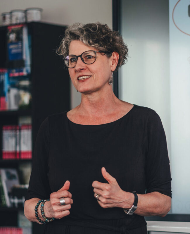 Eine Dozentin am Media Campus Frankfurt (Michaela von Königsmarck) hält eine Präsentation vor einem Whiteboard.