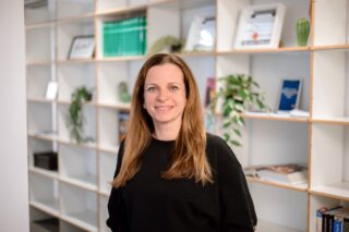 Valeska Wagner steht vor einem Bücherregal im Haus des Buches.