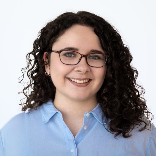 Portrait von Vanessa Demaré die eine blaue Bluse trägt und in die Kamera lächelt