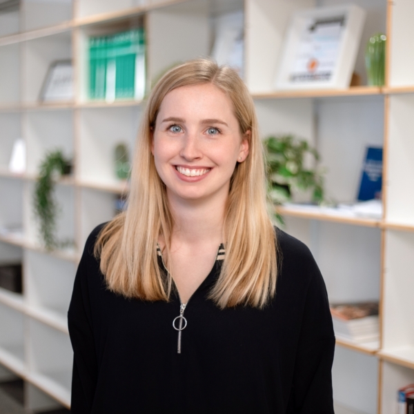 Maren steht vor einem Bücherregal