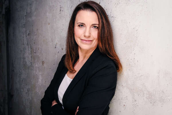 Kirsten Blessing lehnt an einer Wand.