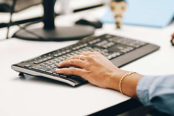 Hände bedienen Tastatur und Maus.