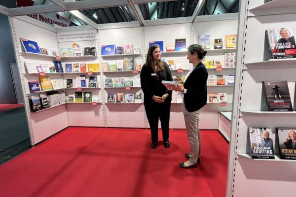 Zwei Frauen unterhalten sich am Stand der Livro Gemeinschaftsausstellung.