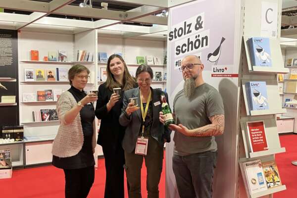 Das Livro-Team stößt nach dem Ende der Messe mit Sekt an.