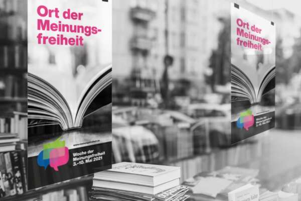 Grafik zur Woche der Meinungsfreiheit 2023 zeigt ein Schaufenster mit Büchern und zwei Plakate auf denen "Ort der Meinungsfreiheit" steht.