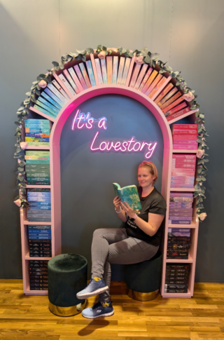 Bloggerin Madame_Anett_liest sitzt unter einem Bücherbogen und liest
