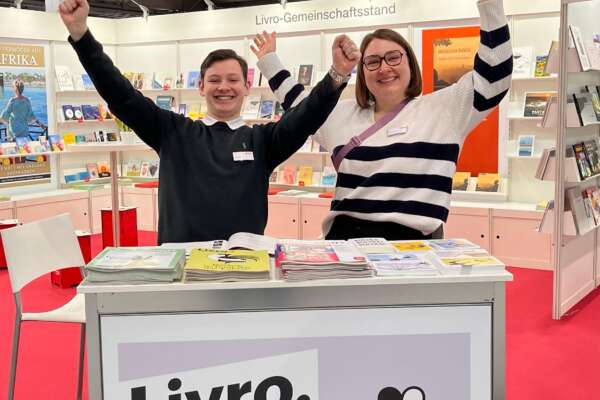 Zwei Personen stehen jubelnd hinter der Livro-Theke