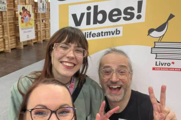 Katrin Friedl, Lorina Bischoff und Markus Fertig machen ein Selfie vor dem Livro-Rollup