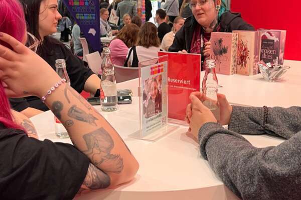 Menschen hören einer Bloggerin bei einer Buchvorstellung zu.