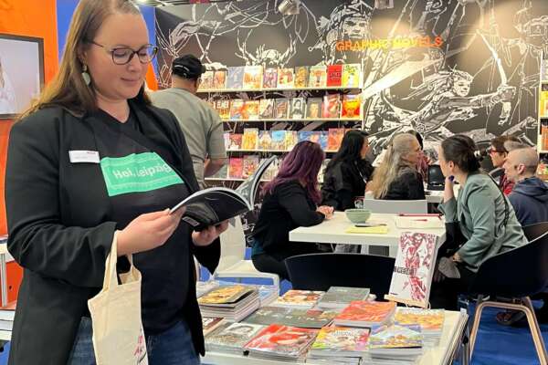 Katrin Friedl steht am Philippinen-Stand und blättert in einem Buch
