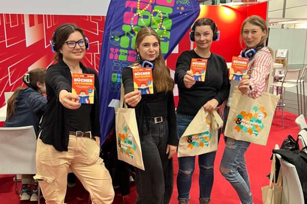 Vier Bloggerinnen halten einen Büchergutschein in der Hand.