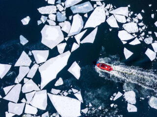 Boot fährt durch gebrochene Eisschollen